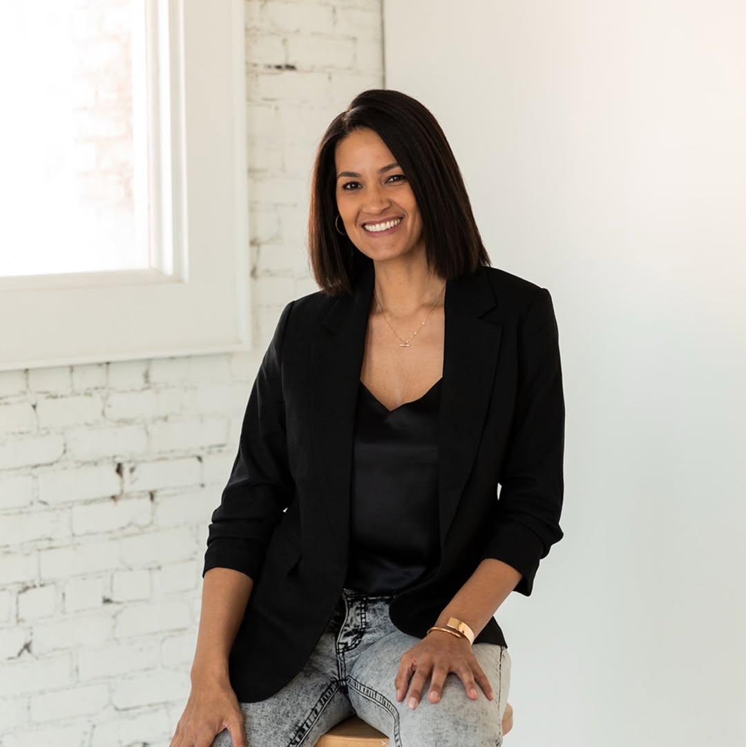 Lisa Warner, owner of Polished Tradition Cleaning Co., seated in front of a brick wall